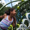 Little girl climbs on a jungle gym in the new playground. thumbnail