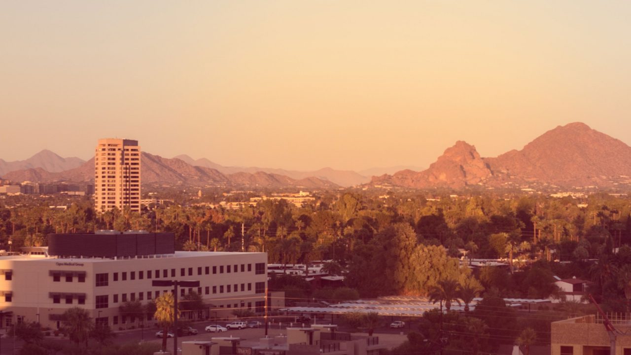 Panoramic view of a desert city surrounded by mountains.