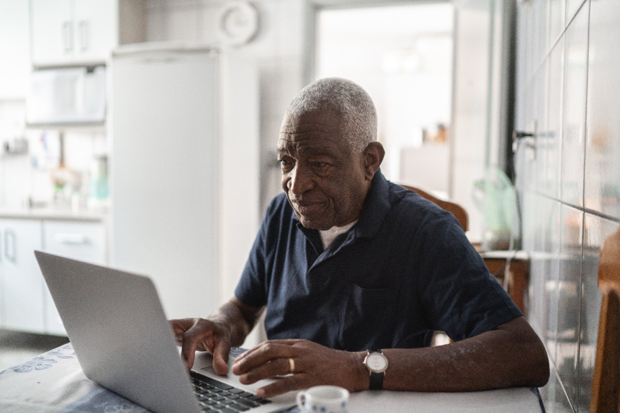A senior man working at a laptop.