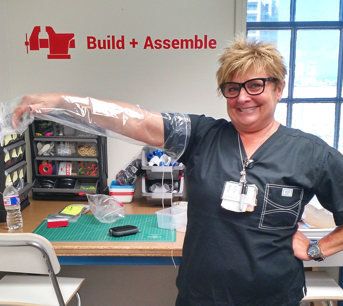 A nurse shows off the prototype of the shower sleeve she designed at the first medical maker space.