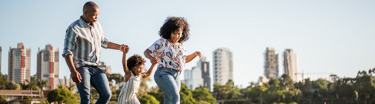 Family strolling in the late afternoon in a city park.