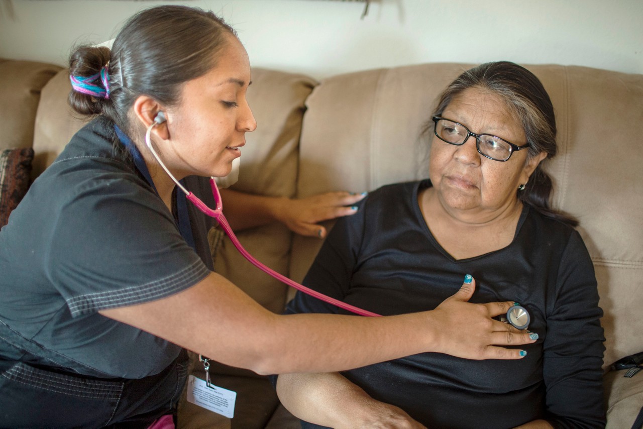 A nurse examining her patient with stethoscope.