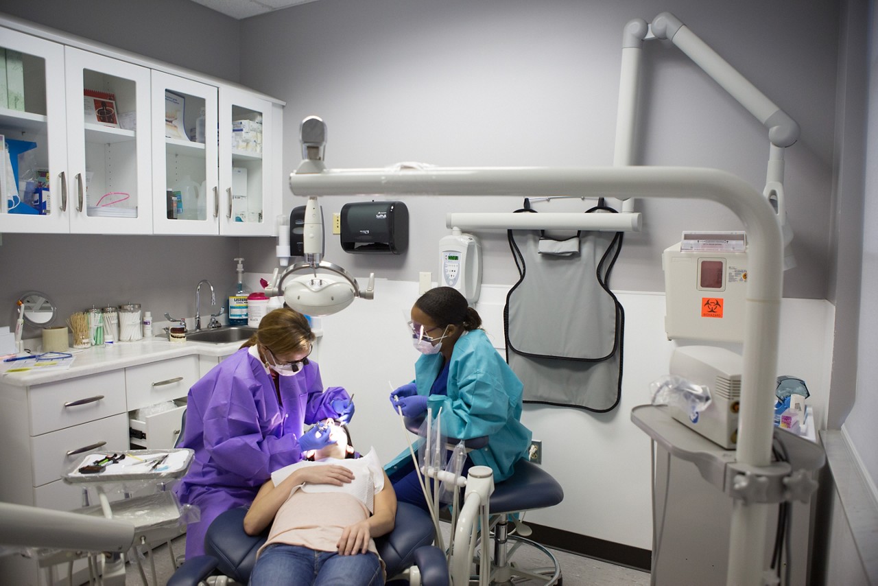 A woman gets her teeth cleaned at the dentist.