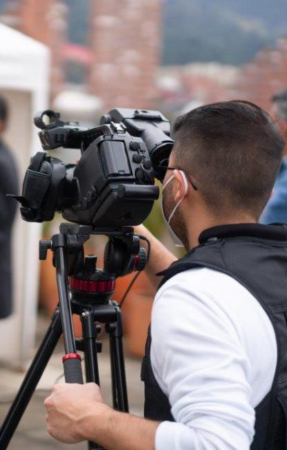 A cameraman recording the latest news from a COVID-19 vaccination stand.