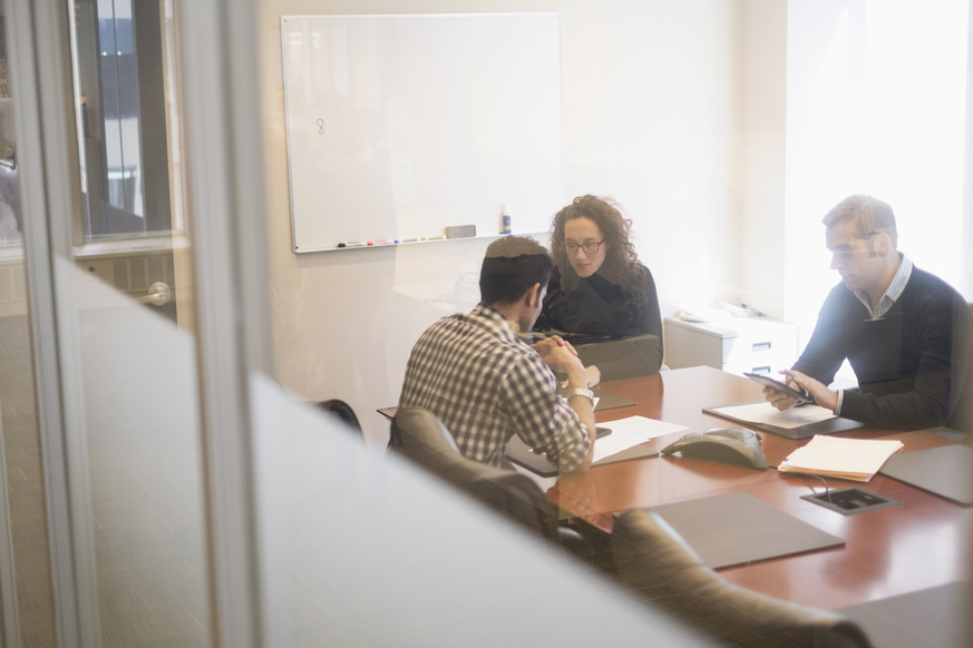 Four young professionals engaging in office meeting. Four young professionals engaging in office meeting.