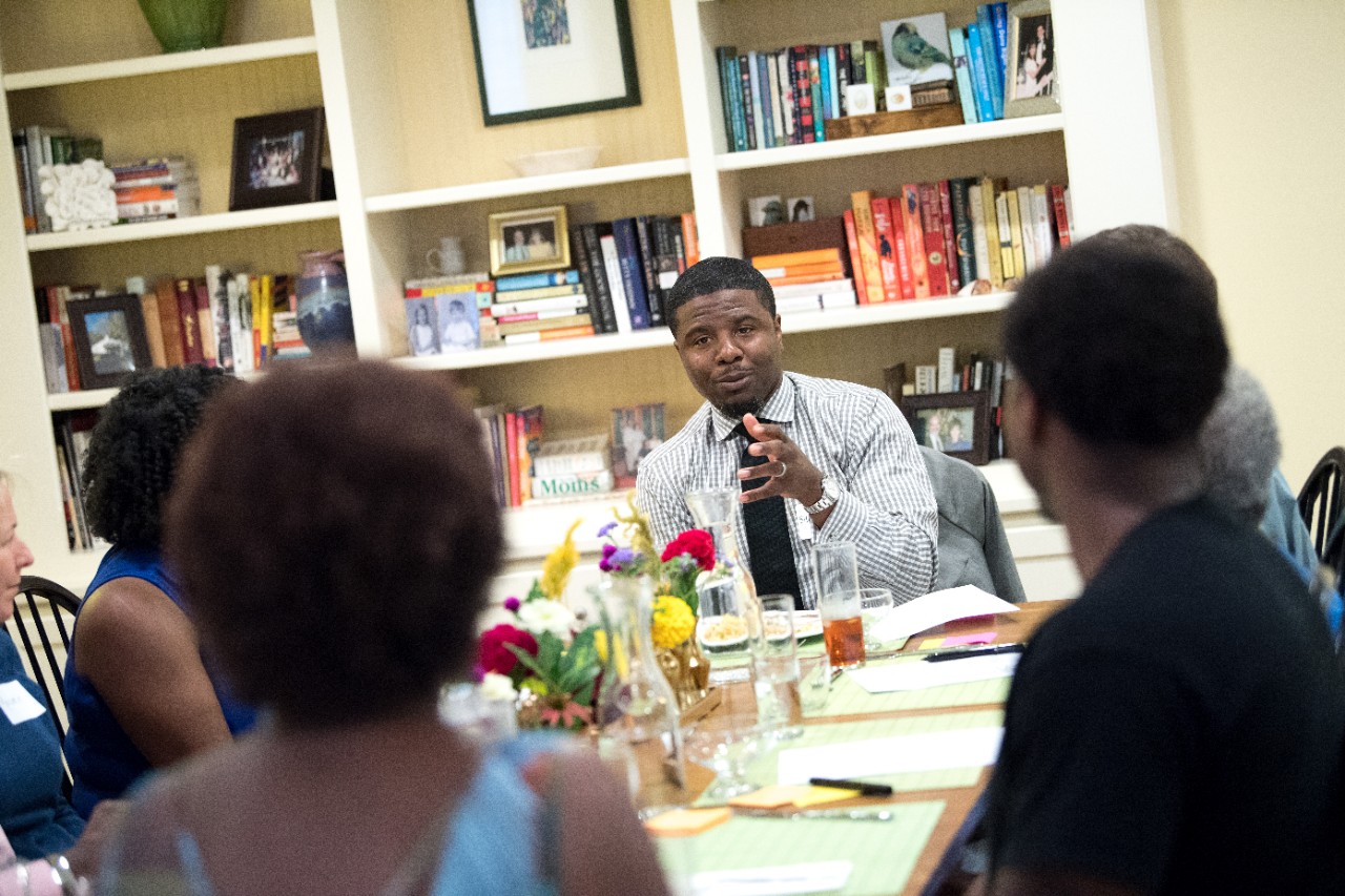 A man speaking with community leaders and activists.