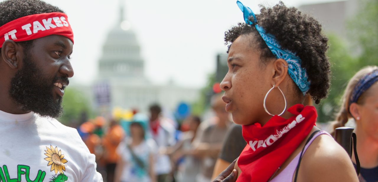 A mother holding her infant son who has a pacifier in his mouth.
