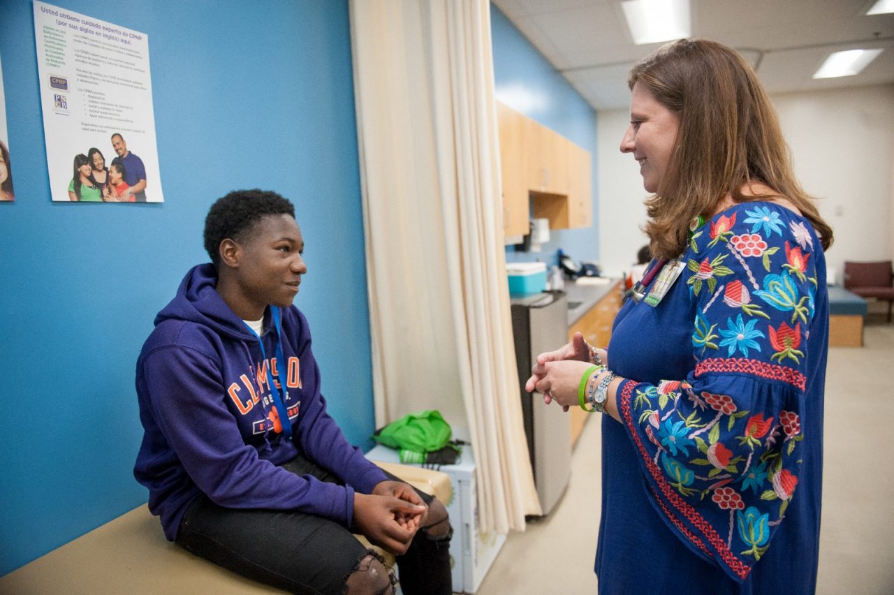 A nurse talking with a student during a sports physical.