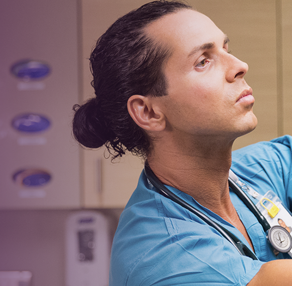 A nurse adjusts a monitor in a patient's hospital room.