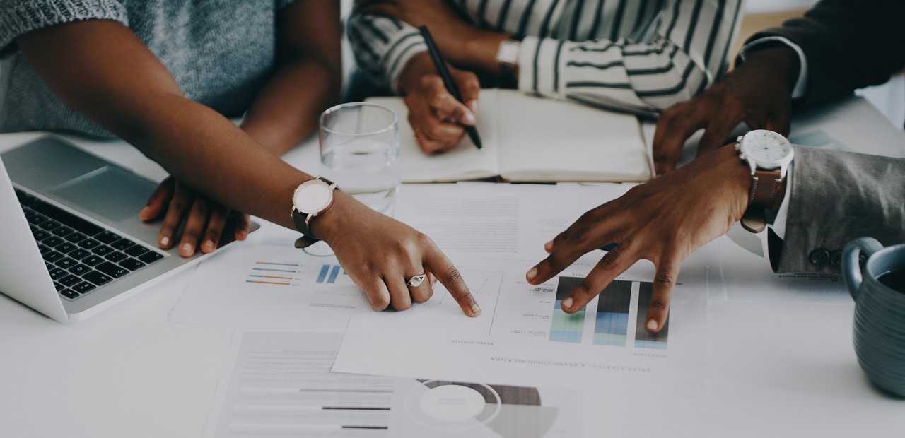 Closeup shot of a group of unrecognisable businesspeople analysing graphs in an office Closeup shot of a group of unrecognisable businesspeople analysing graphs in an office