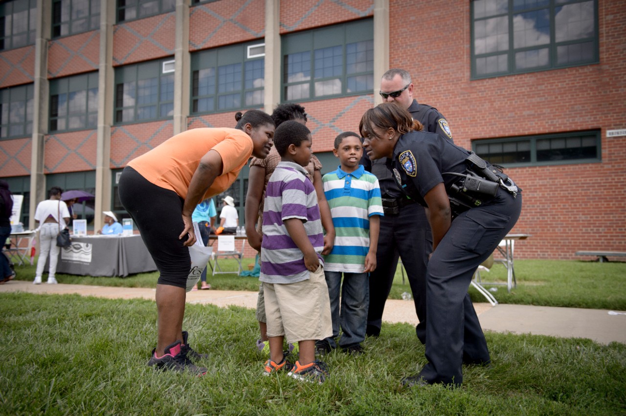 School Resource Officer Tameika Sanders talks with students and parents during Beyond Housing's "Beyond the Backpack" event on Saturday, Aug. 6, 2016. The event, held at Normandy High School in Northern St. Louis County, Mo., provided families in the 24:1 communities with back-to-school resources, including immunizations and haircuts.