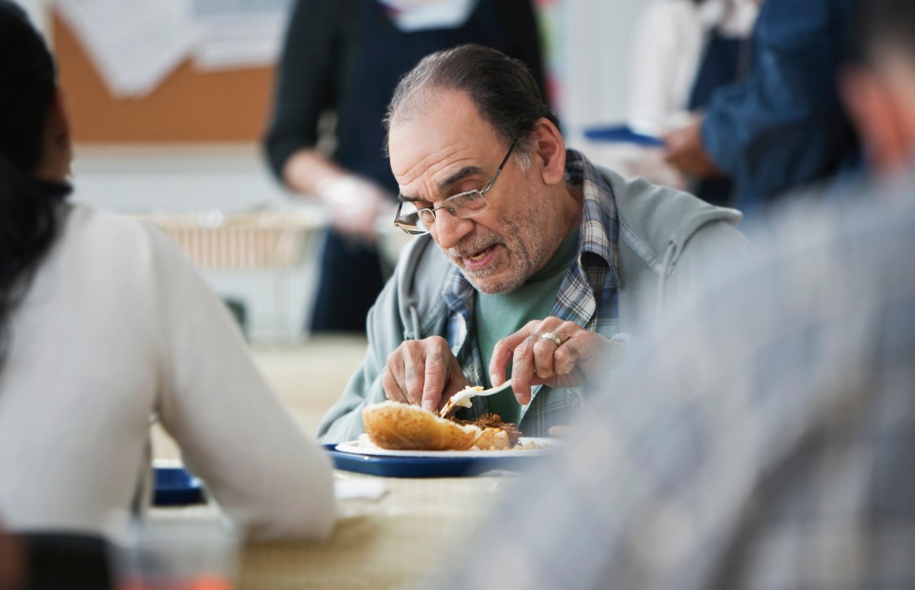 People enjoying their meal at the community food bank People enjoying their meal at the community food bank