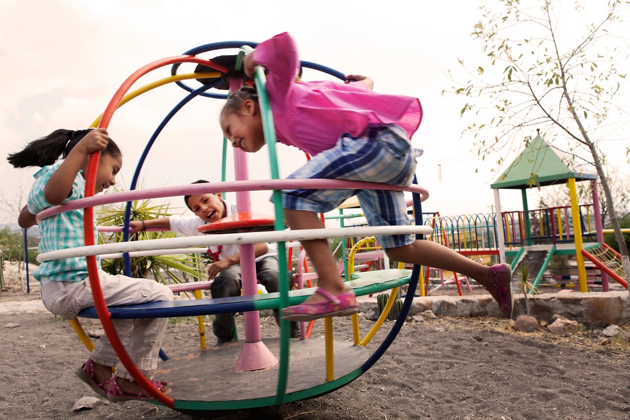 Three children playing at a playground.. Three children playing at a playground..