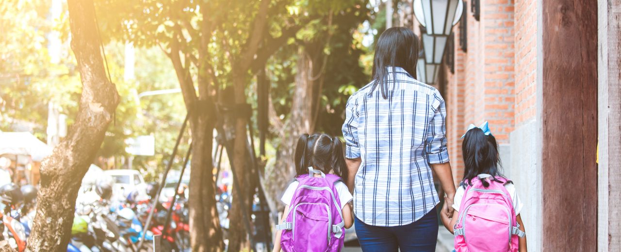 Back to school. Asian mother and daughter pupil girl with backpack holding hand and going to school together