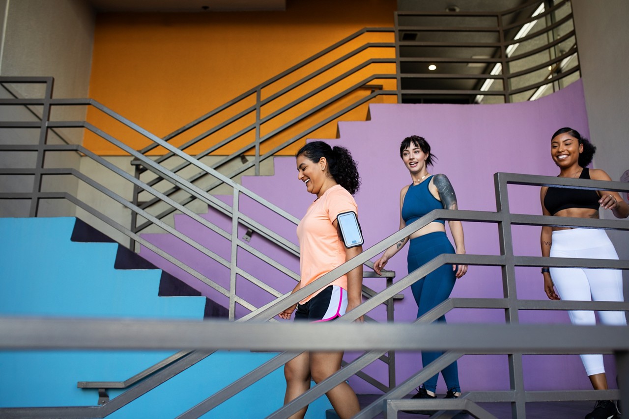 Rich Besser, RWJF President & CEO walks outside a building and listens to recipients of 2018 Culture of Health Prize. Rich visits Culture of Health Prize recipient, Eatonville, Florida. Adult black woman age 30-40 using hands, talking to Rich.