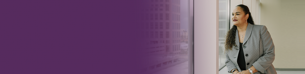 A woman looking out a window of an office building.