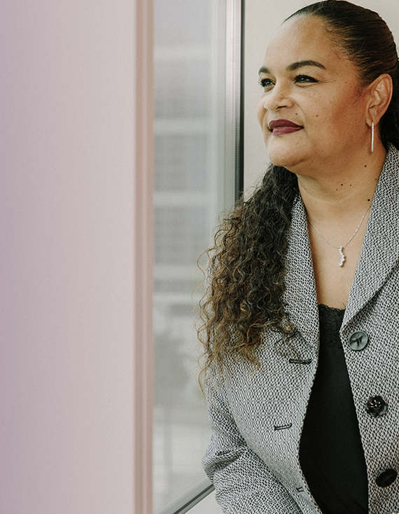 A woman looking out a window of an office building.