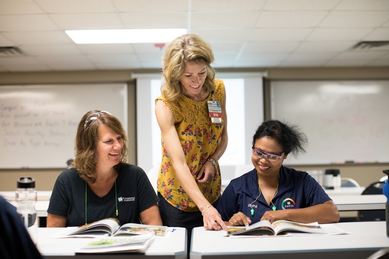 A teacher and adult students participating in class.