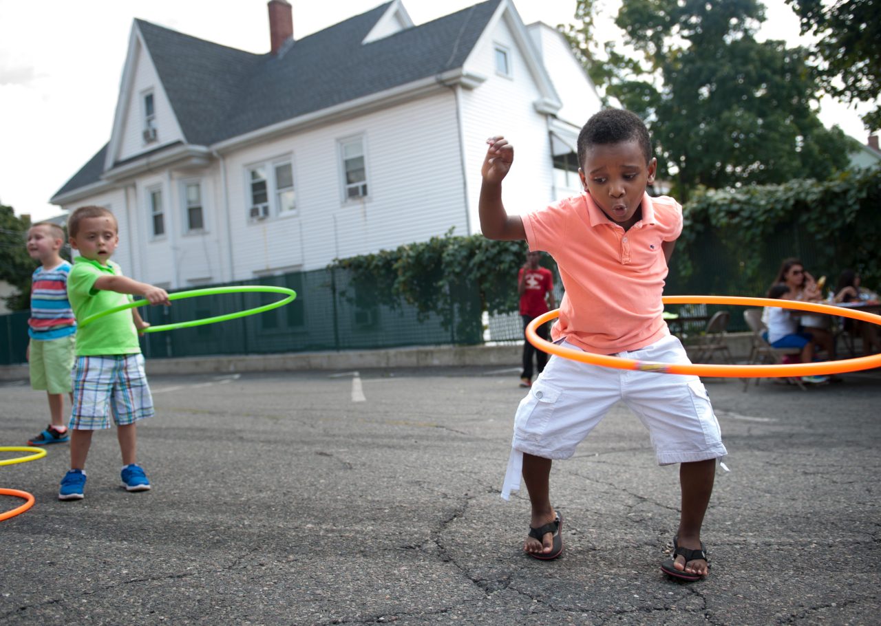 A boy hula hoops during a block party.