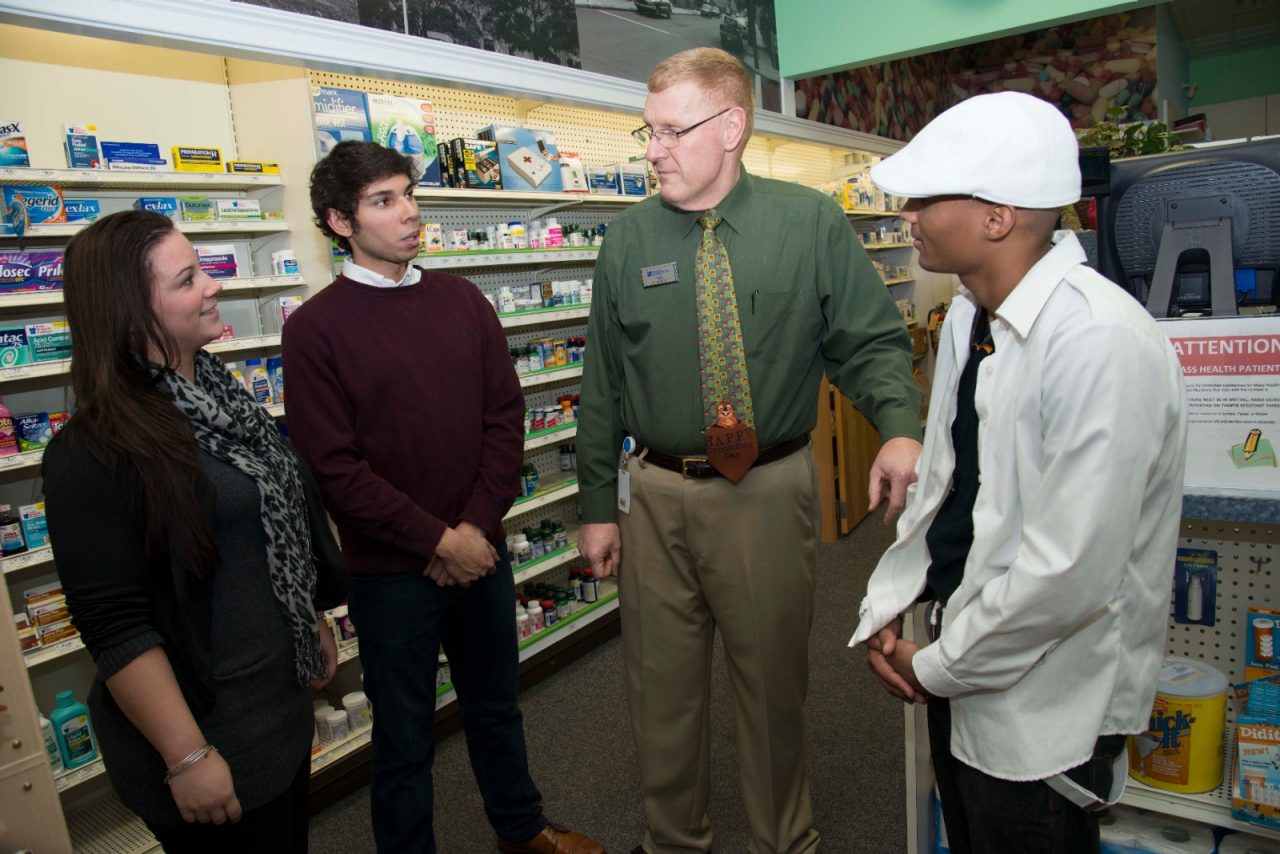 A group of adults talking in a pharmacy.