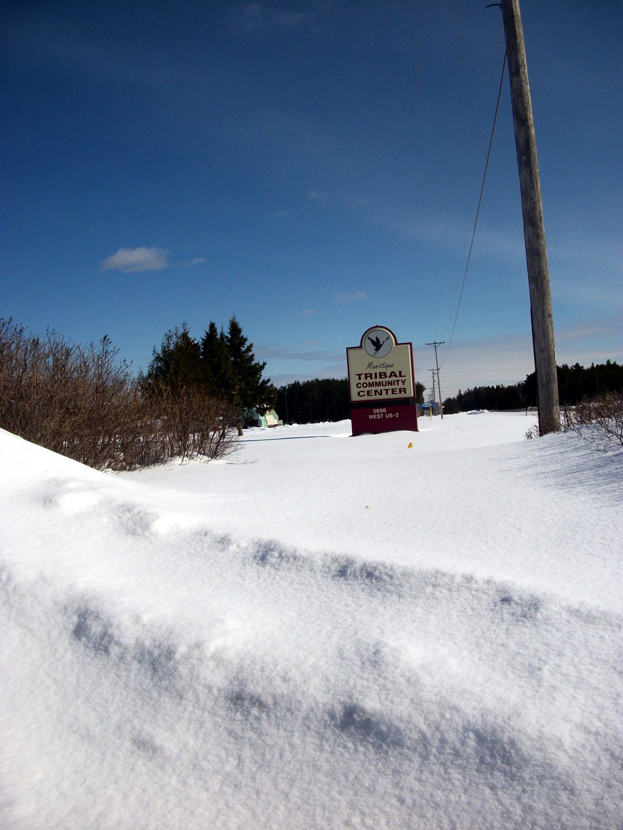 A town sign on a snow-covered road.