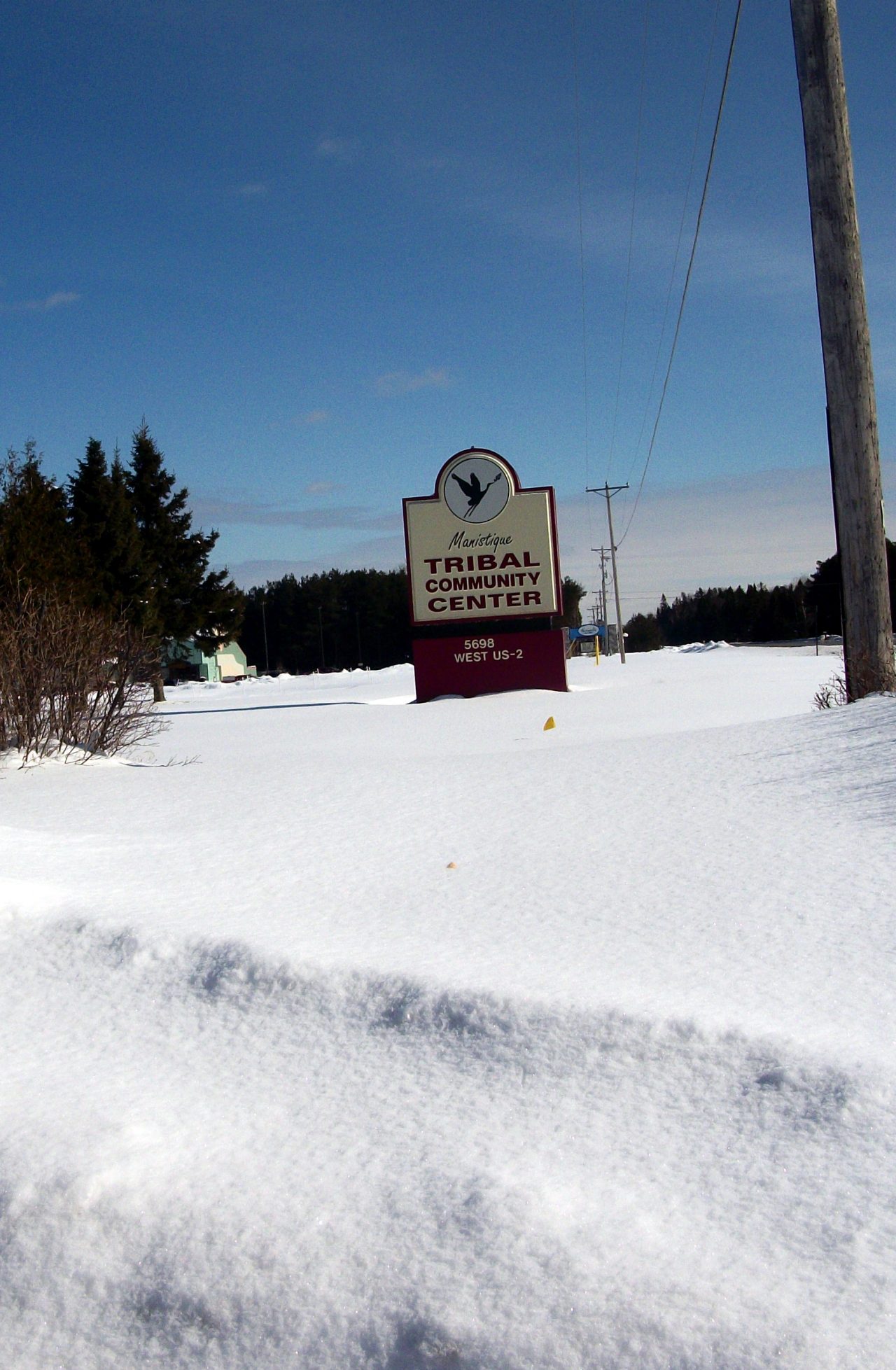 A town sign on a snow-covered road.