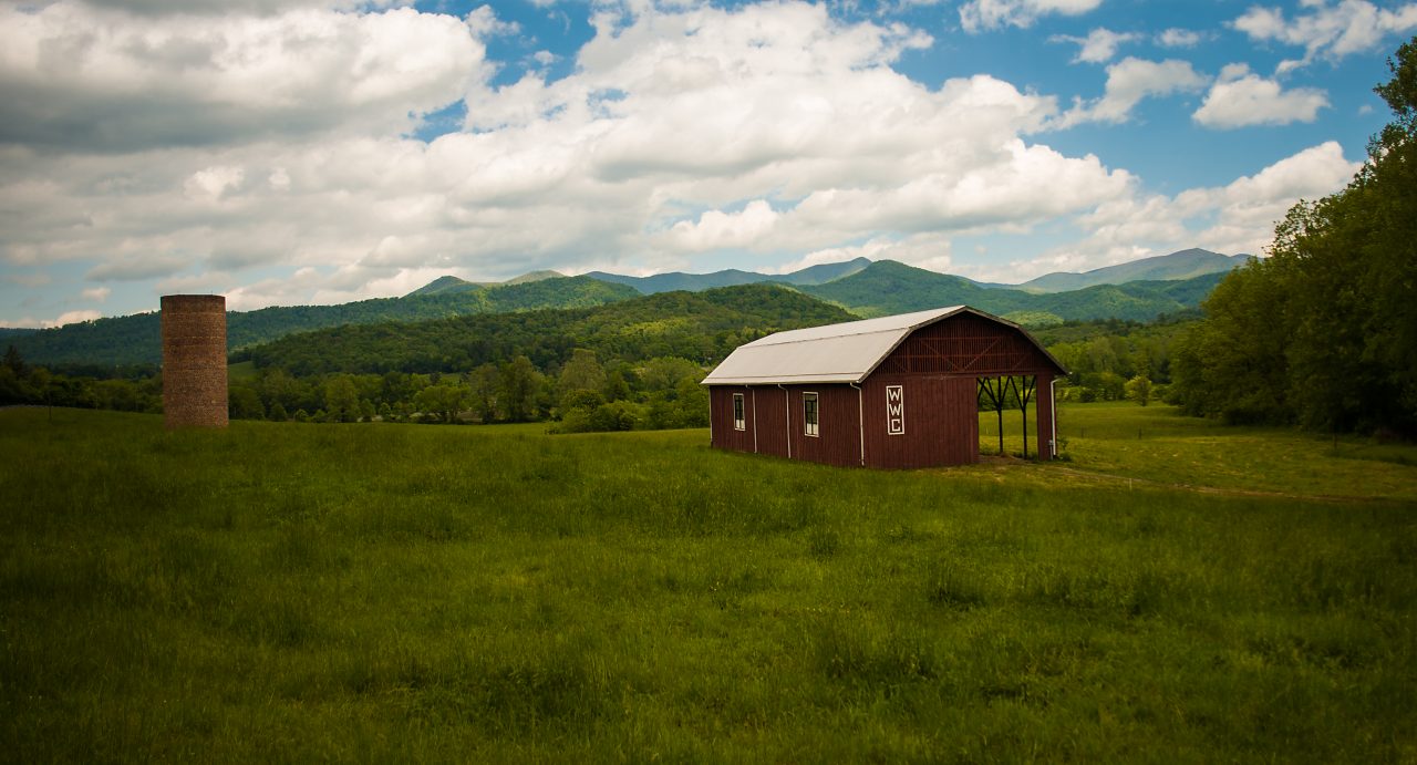 A farmhouse situated among acres of lush farmland.