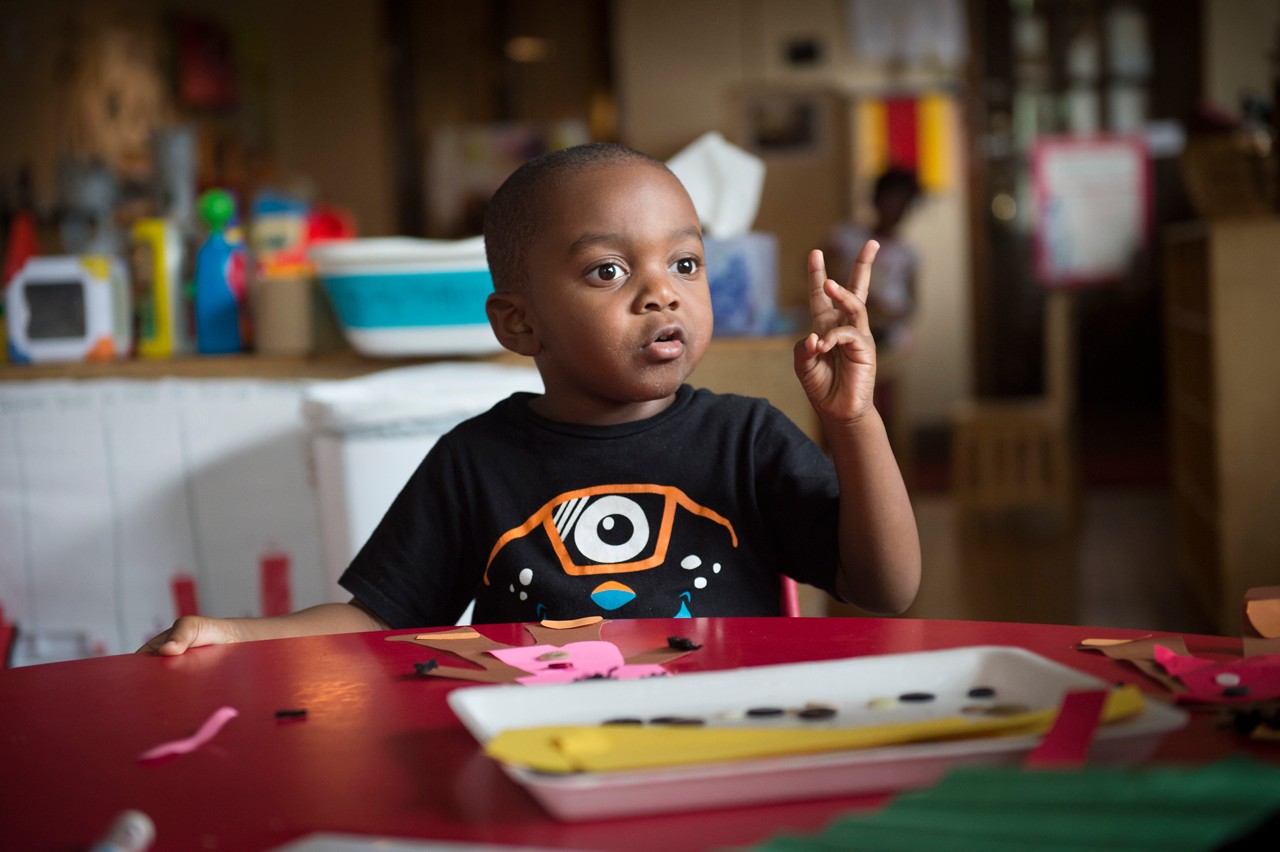 A toddler boy in a daycare setting.