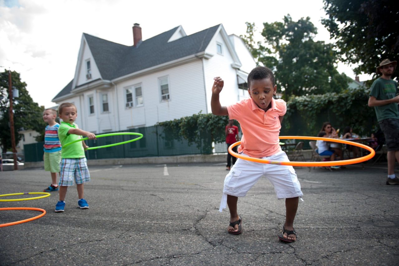 A boy hula hoops during a block party.