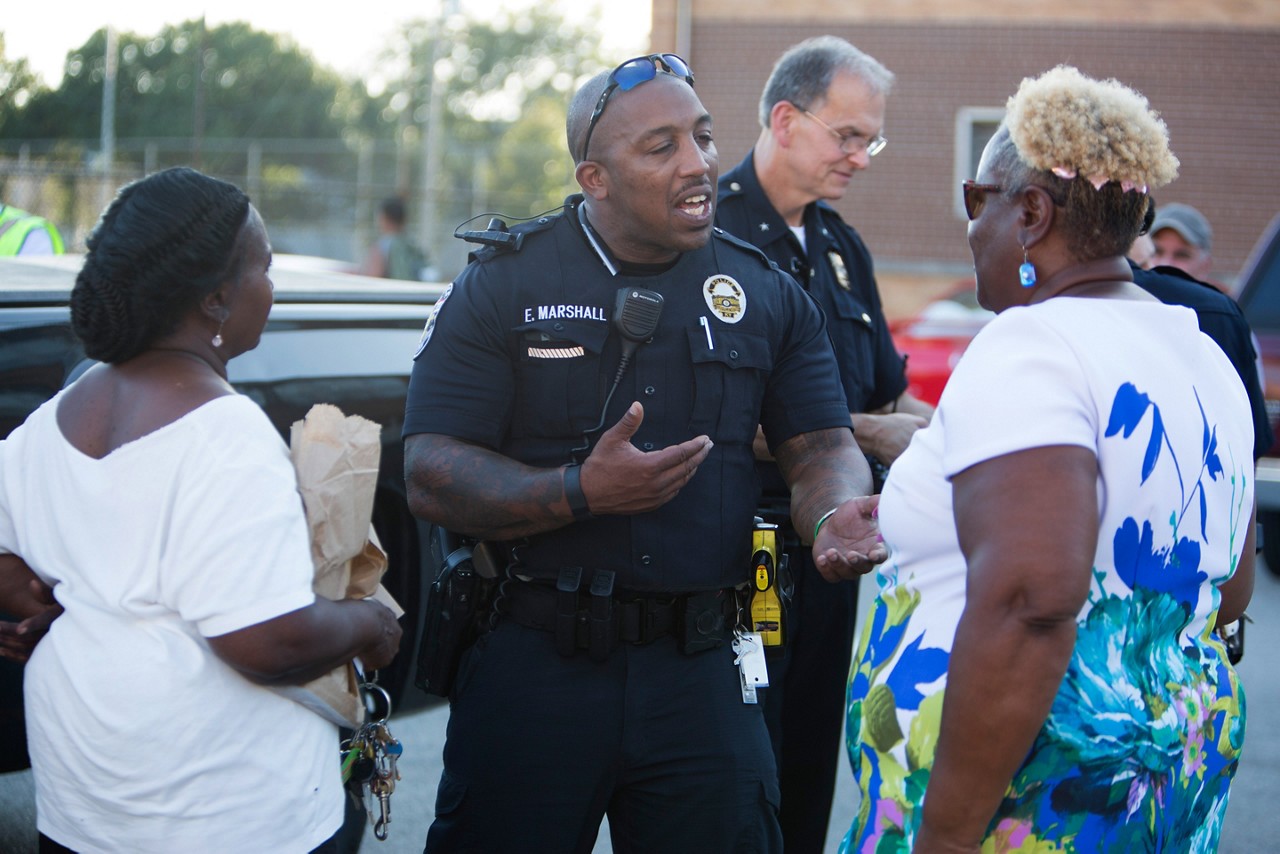 Two police officers meeting with community leaders.