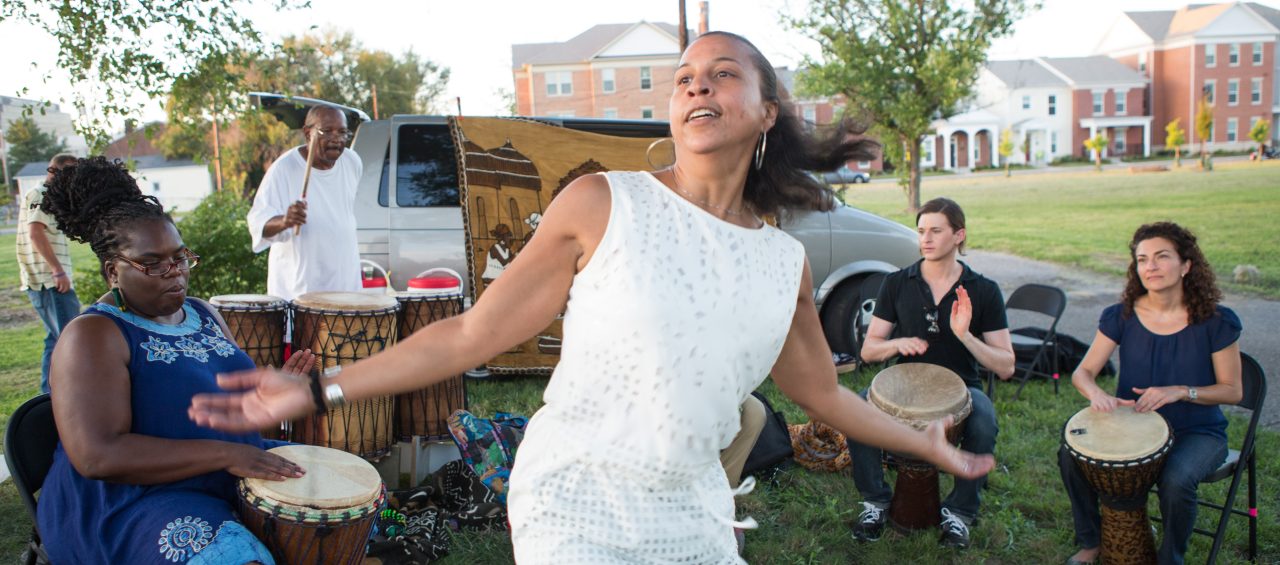 RWJF COH Louisville August 25-28, 2016 Project H.E.A.L. (Health. Equity. Art. Learning.) drum circle in the Smoketown neighborhood of Louisville, led by drummer Gregory Acker. In this picture, Cynthia Brown dances to the beat of the group.Project H.E.A.L. (Health. Equity. Art. Learning.) drum circle in the Smoketown neighborhood of Louisville, led by drummer Gregory Acker. In this picture, Cynthia Brown dances to the beat of the group.
