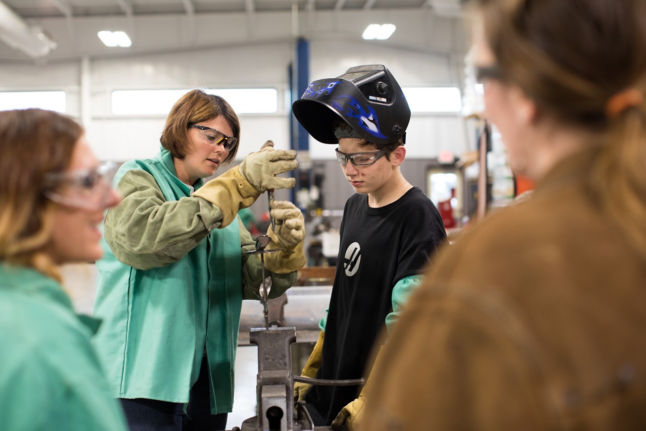 Rachel Schneider (center-left) begins to assemble a rose garden ornament.