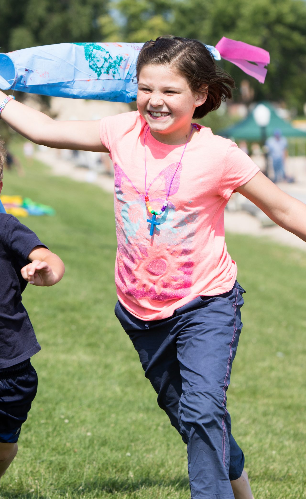 Two children running with kites.