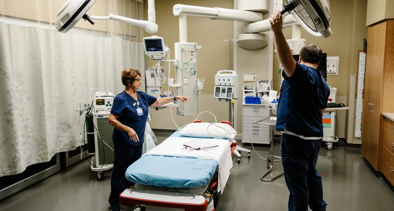 Nurses prep an emergency exam room. 