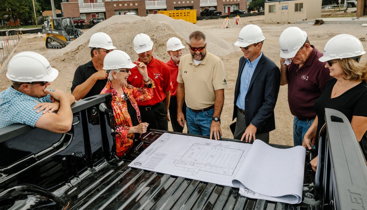 Construction staff and community officials discuss plans for a new store. 