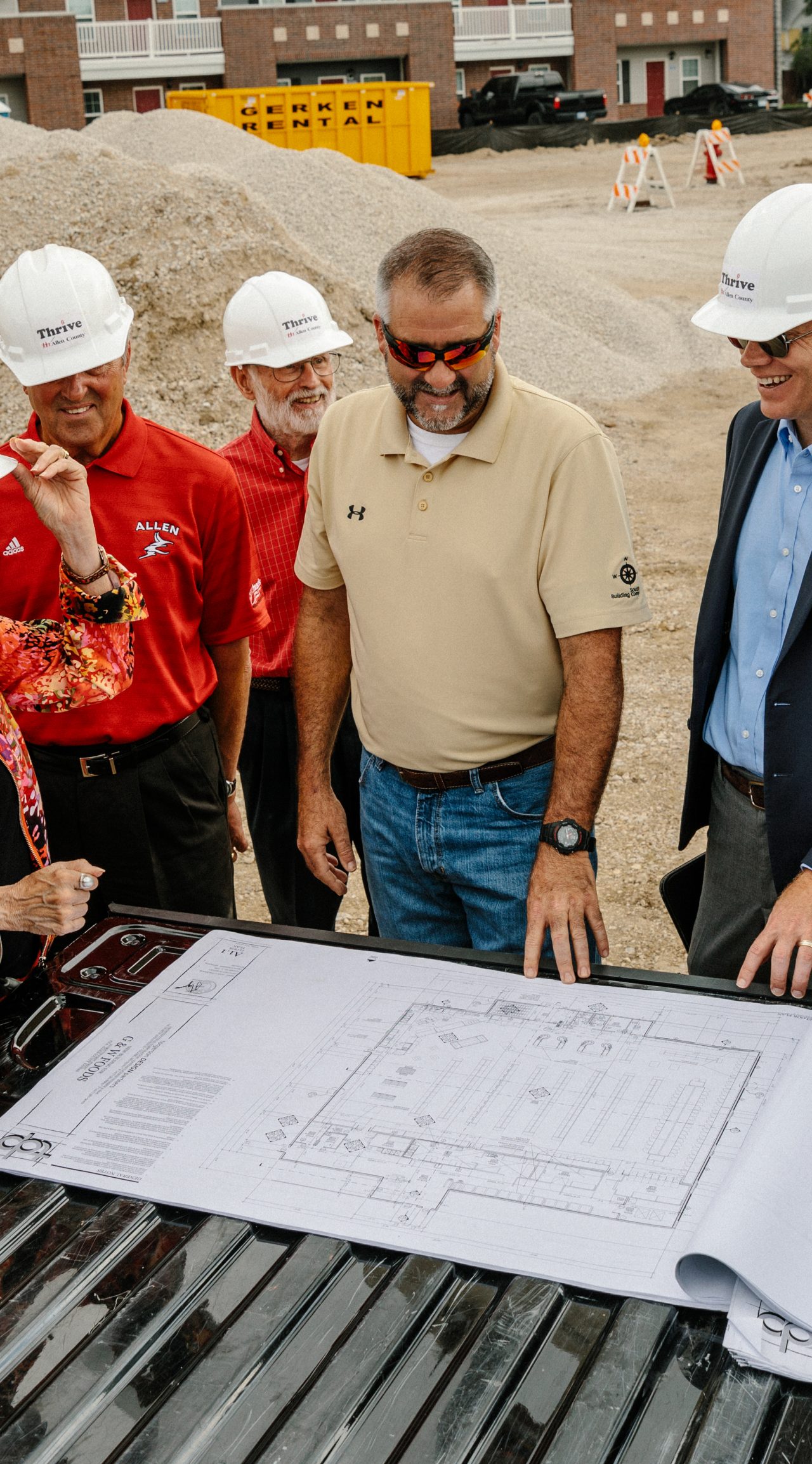 Construction staff and community officials discuss plans for a new store. 