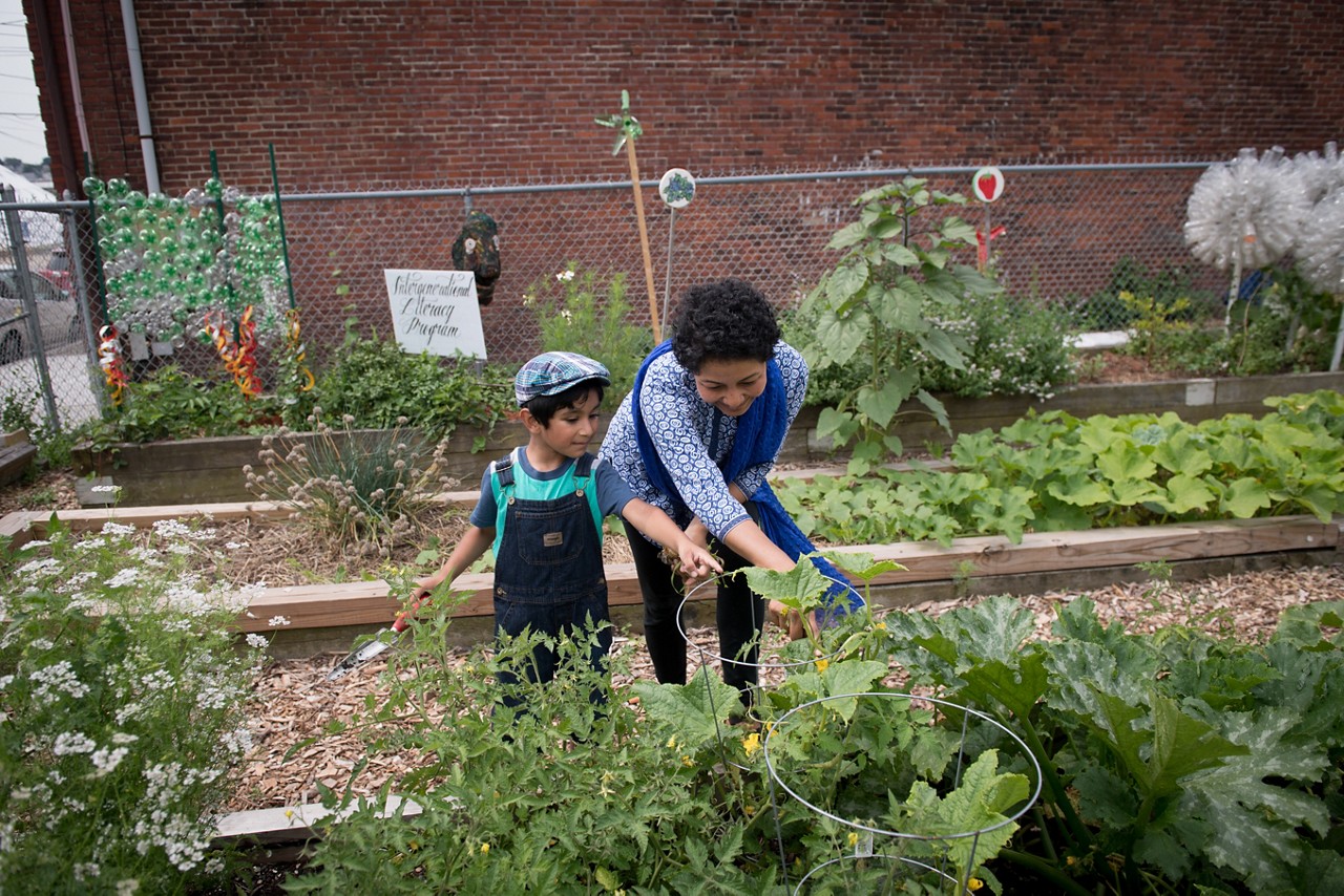 Zinnat Rahana, who is originally from Bangladesh, and her son, Zahin Zawad, 5, harvest vegetables.