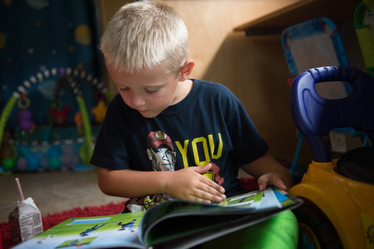 A young boy reading a book. 