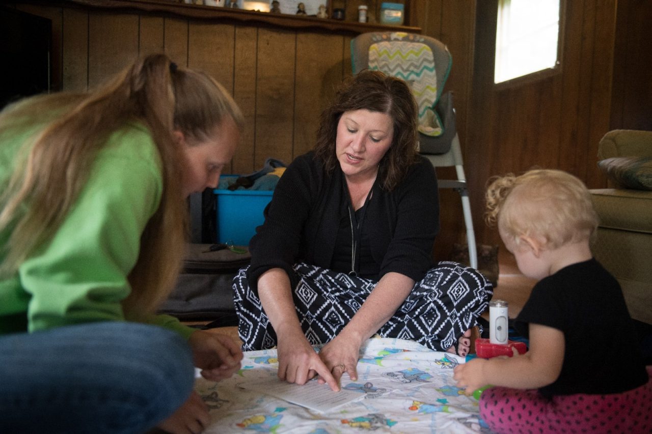 An early care specialist visits with mother and daughter who participate in family care program.