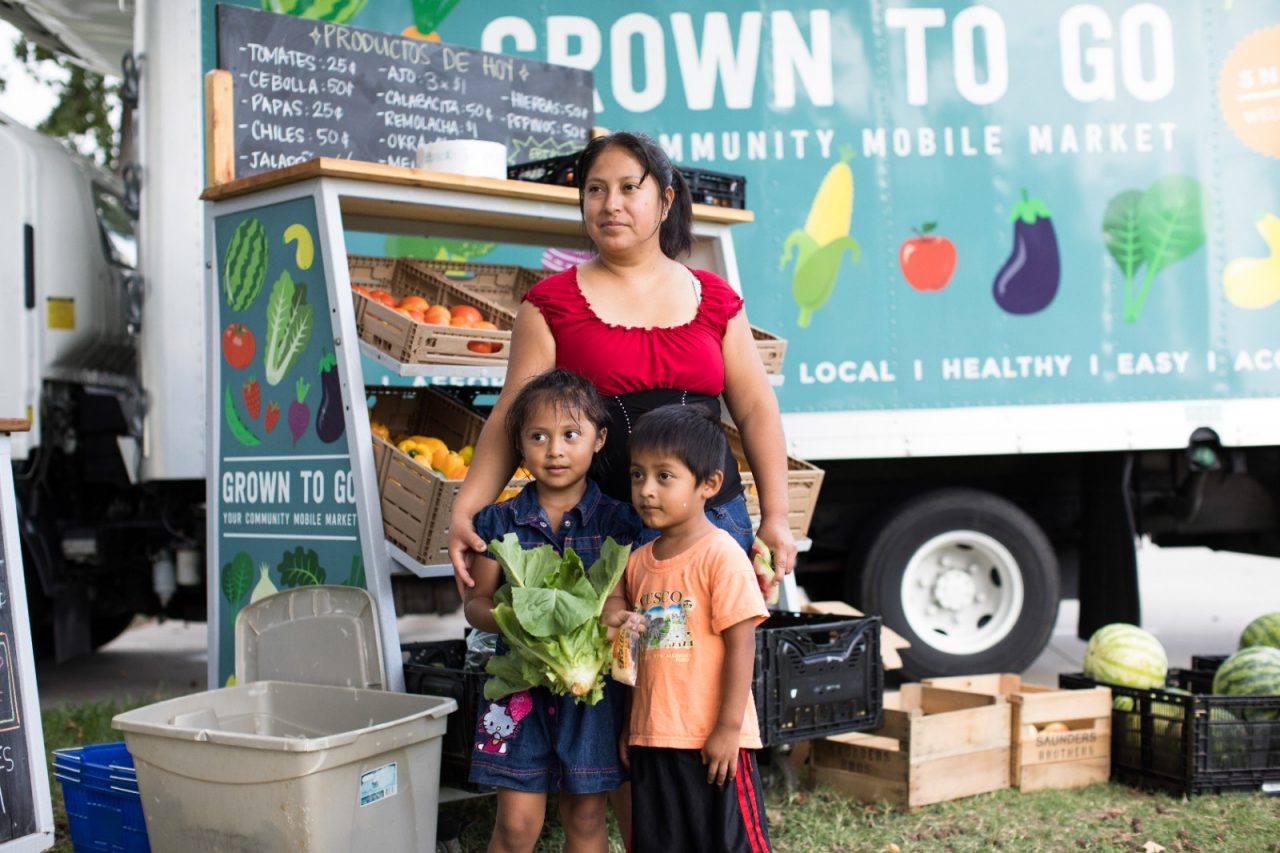A family standing next to a mobile market. 