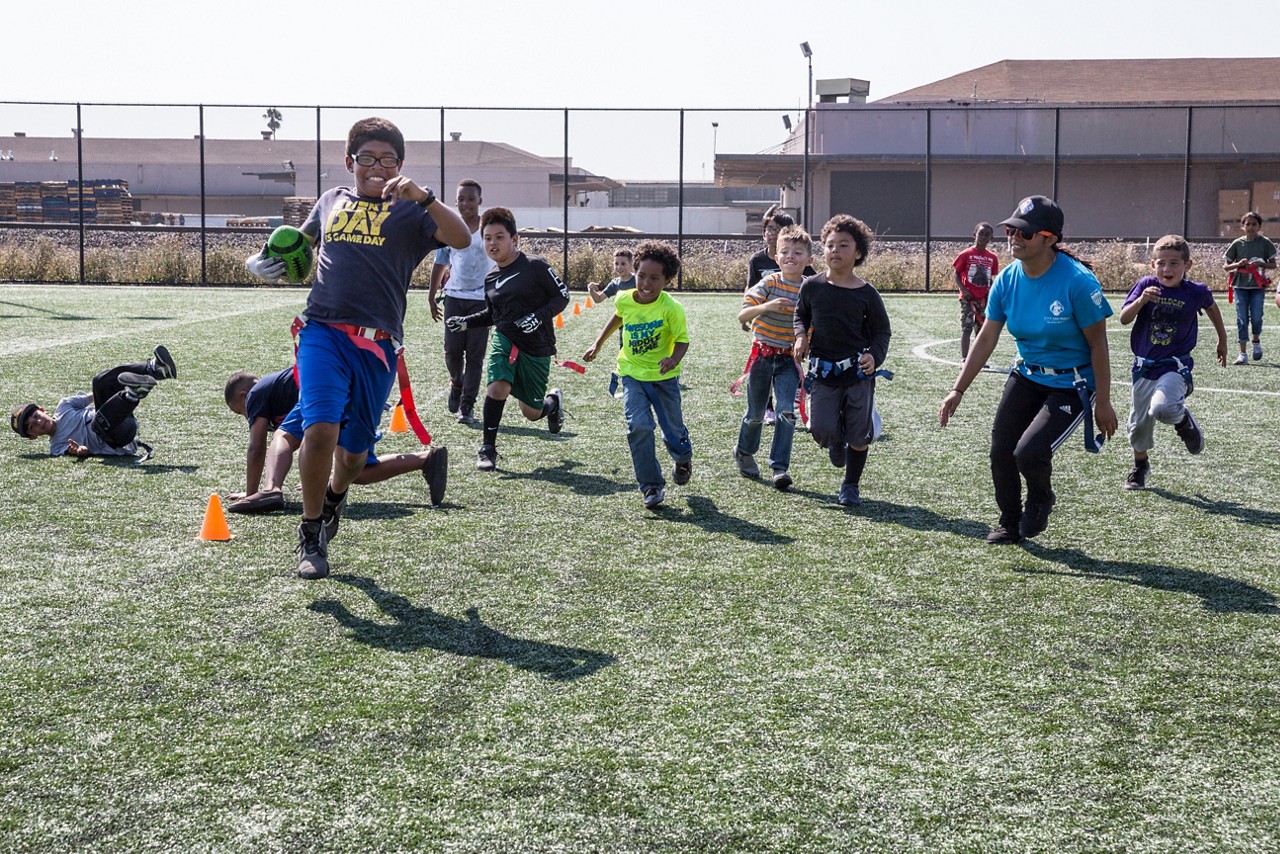 Children playing flag football on an outdoor field. 