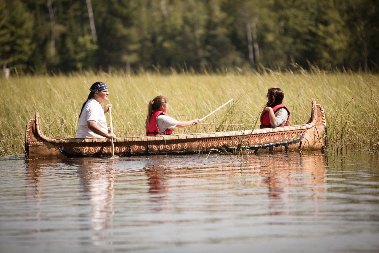 A family canoeing to harvest wild rice.