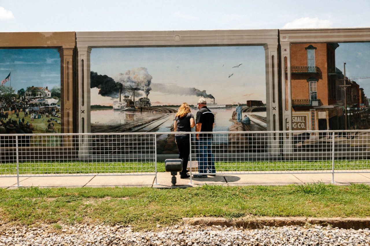 Visitors pause to inspect one of two dozen murals on the floodwalls along the Yazoo River, near Catfish Row in downtown Vicksburg.