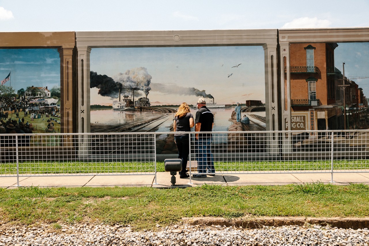 Visitors pause to inspect one of two dozen murals on the floodwalls along the Yazoo River, near Catfish Row in downtown Vicksburg.