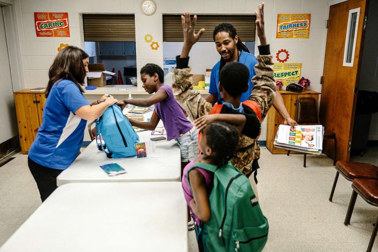 Children receiving school supplies at a back-to-school event. 