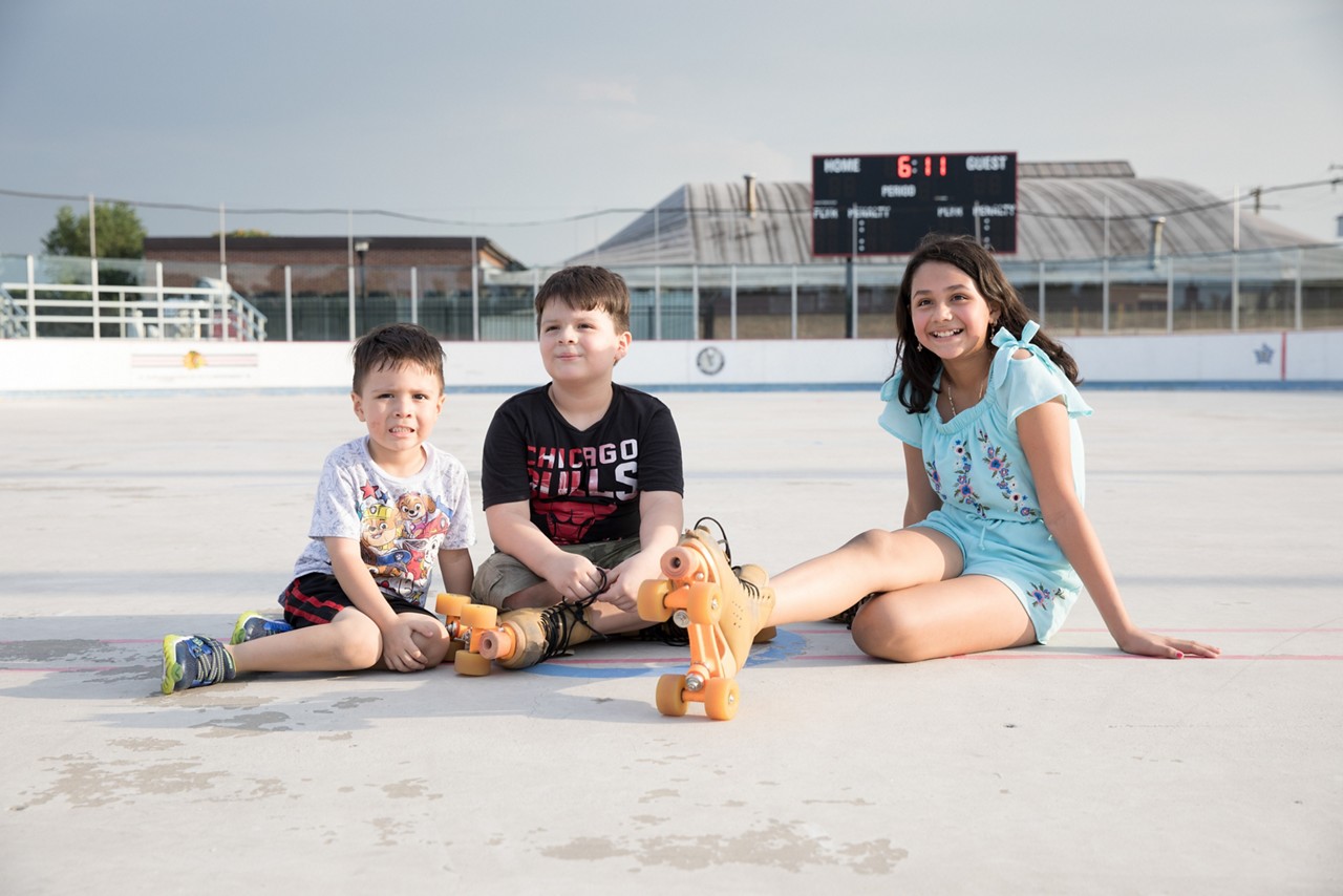 Three sibling playing together at a community public space.