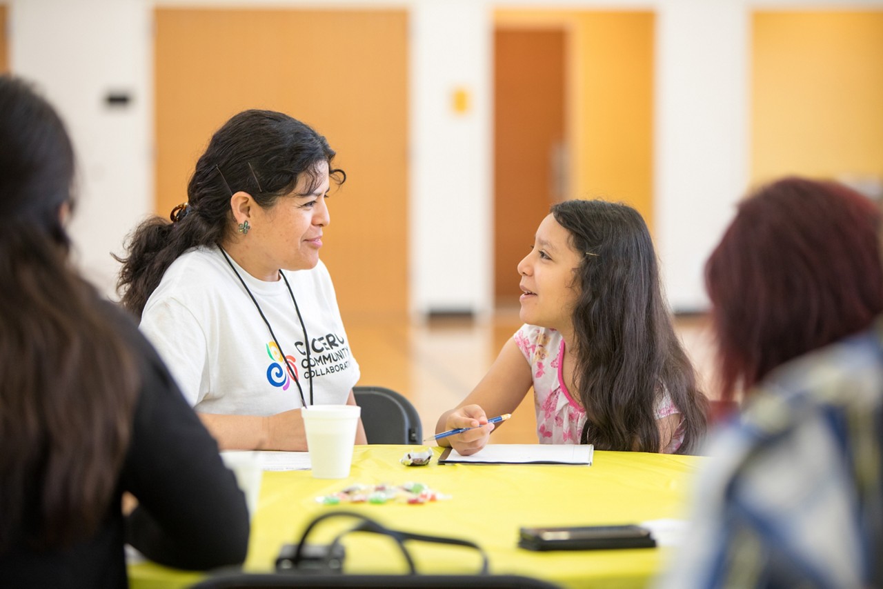 A community worker talking with a teenage girl.