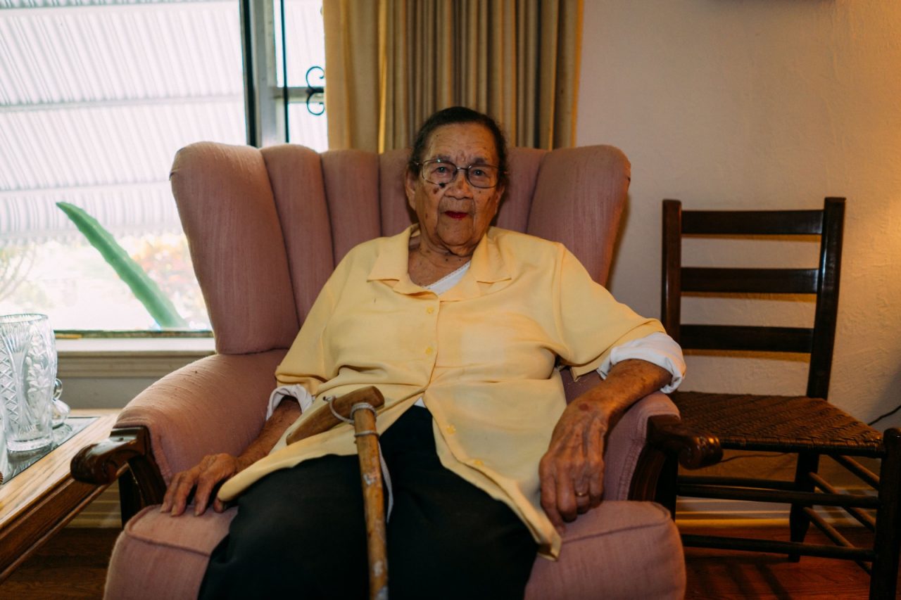 A centenarian sitting in her living room.