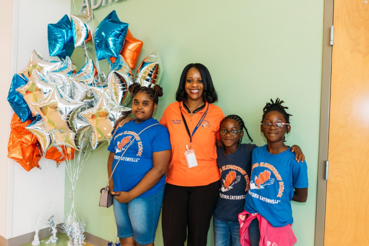 Principal Letecia Foster standing with three students in Hungerford Elementary School.