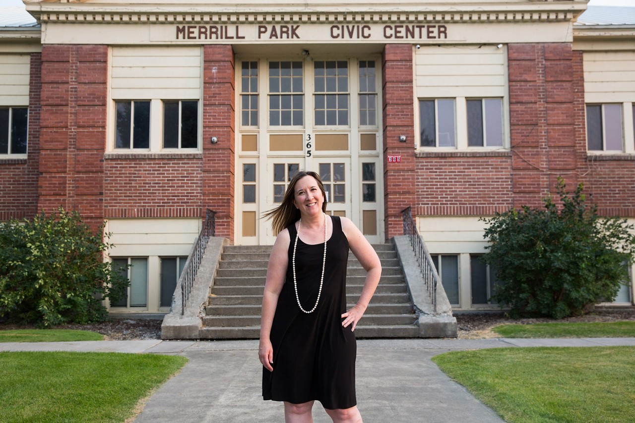 A woman standing in front of a town civic center.